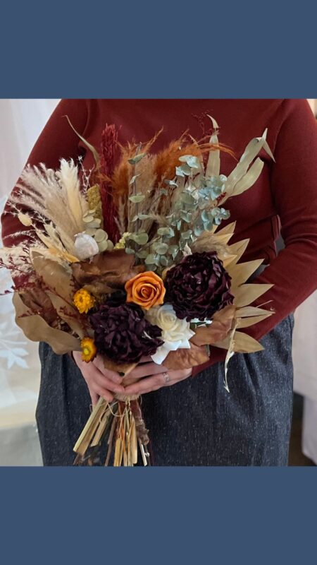 Autumn Dried bouquet of red, orange and yellow flowers with dried palms and pampas grass.