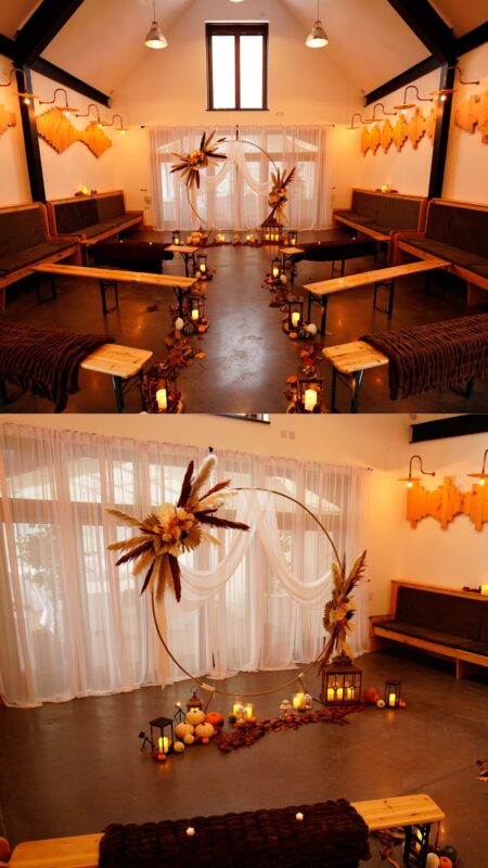 Venue Set up autumnal boho with orange and yellow flowers and palms in a circle arch at the top of the wedding aisle.