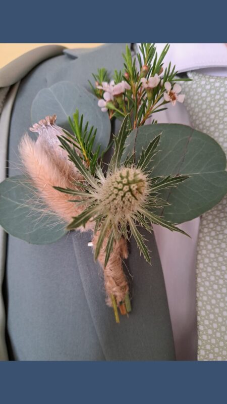 Buttonhole for a sage theme wedding with bunny tail, thistle and eucalyptus