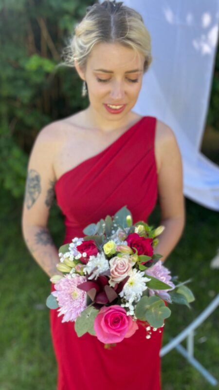 Classic oval bridesmaid bouquet with pink roses and other flowers.