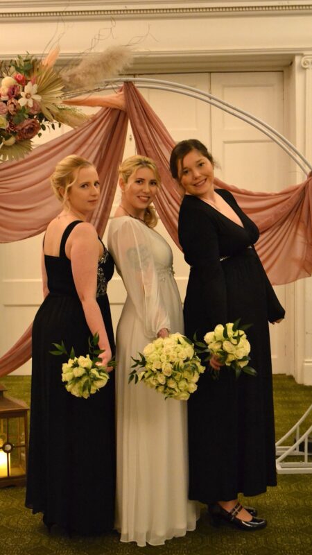 Monochrome wedding theme. Bride is in white and bridesmaids in black. The bride has white rose bouquets.