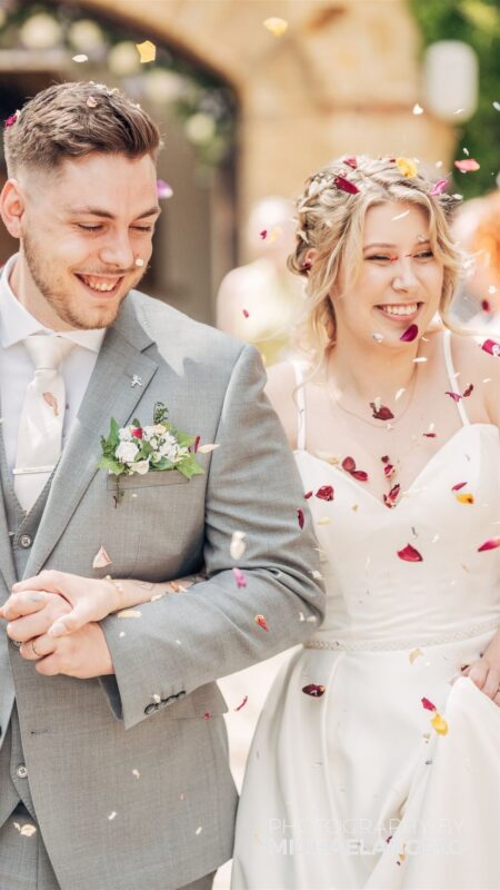 Couple walk through confetti throw.