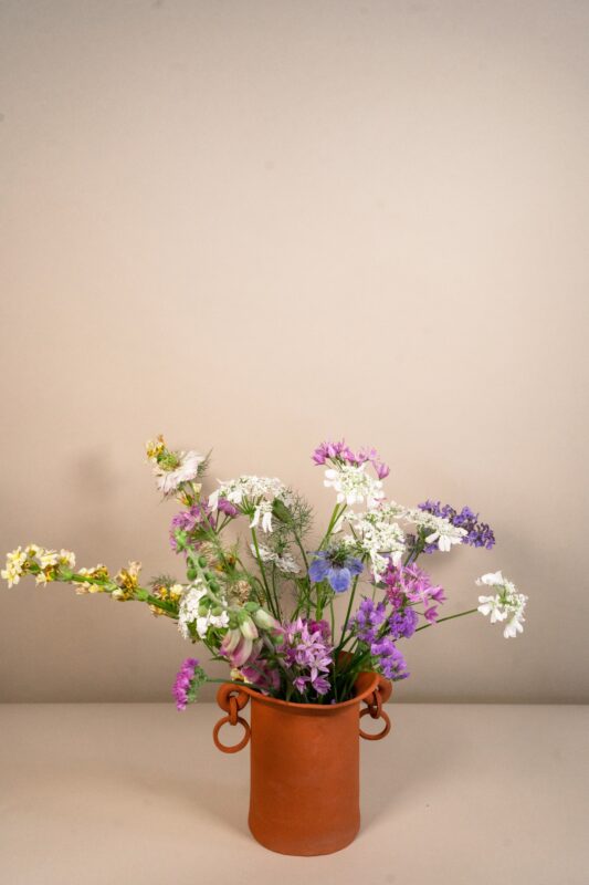 Mudfired Vase filled with blooming roza's flowers